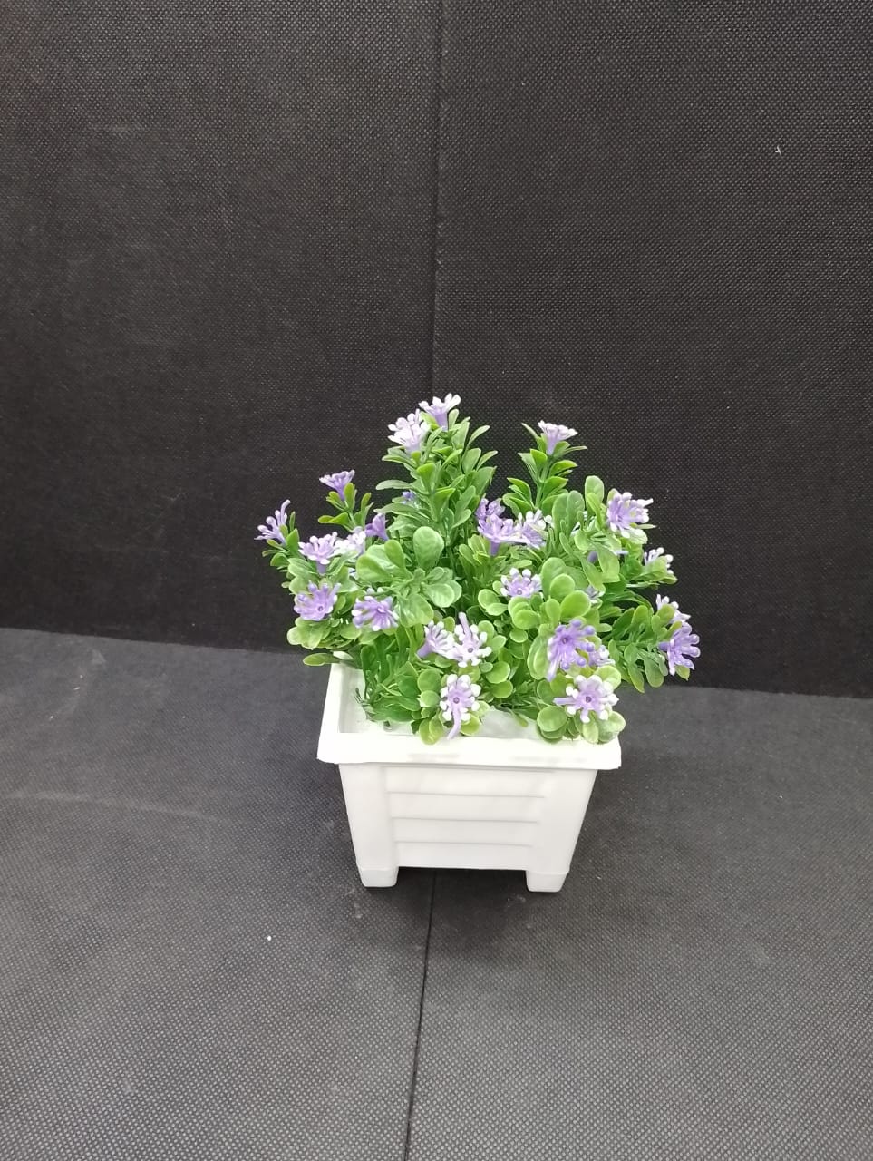 Artificial flower with white vase  This beautifully piece adds a touch of nature and elegance to any room, creating a soothing and inviting atmosphere. The realistic design makes it a perfect piece fo