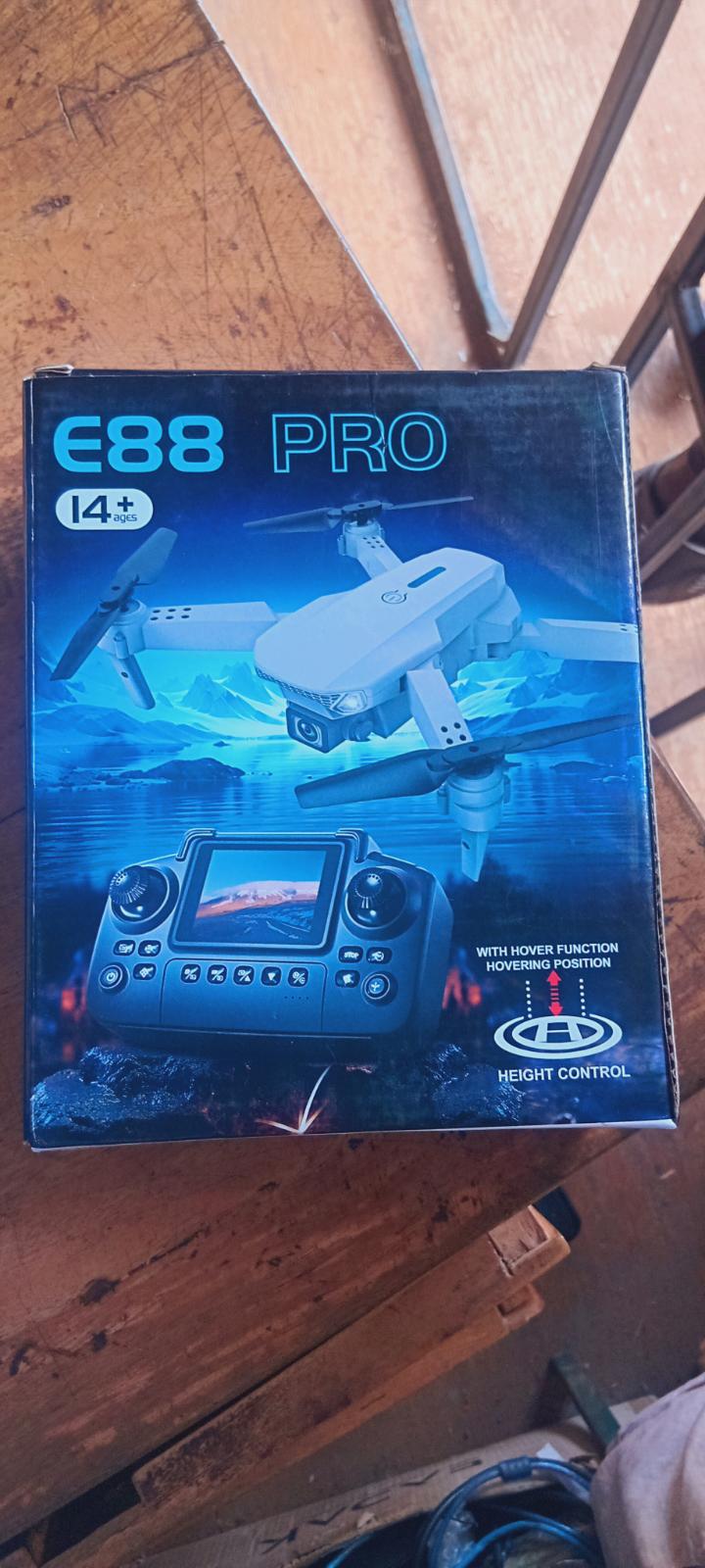 E88 Pro foldable quadcopter drone featuring a camera and a remote controller with an integrated screen for first-person view. 
Camera: Equipped with a 4K UHD camera.
Features: Includes altitude hold (