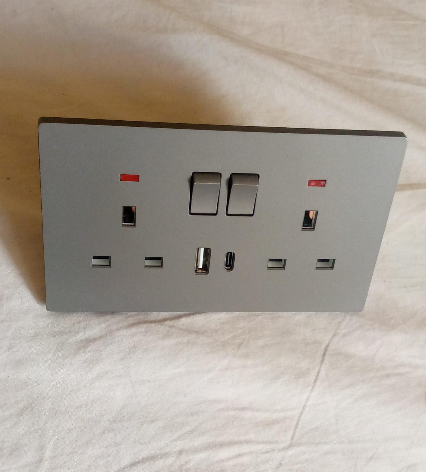 Double socket grey-finished double 13A switched wall socket featuring built-in USB-A and USB-C charging ports.