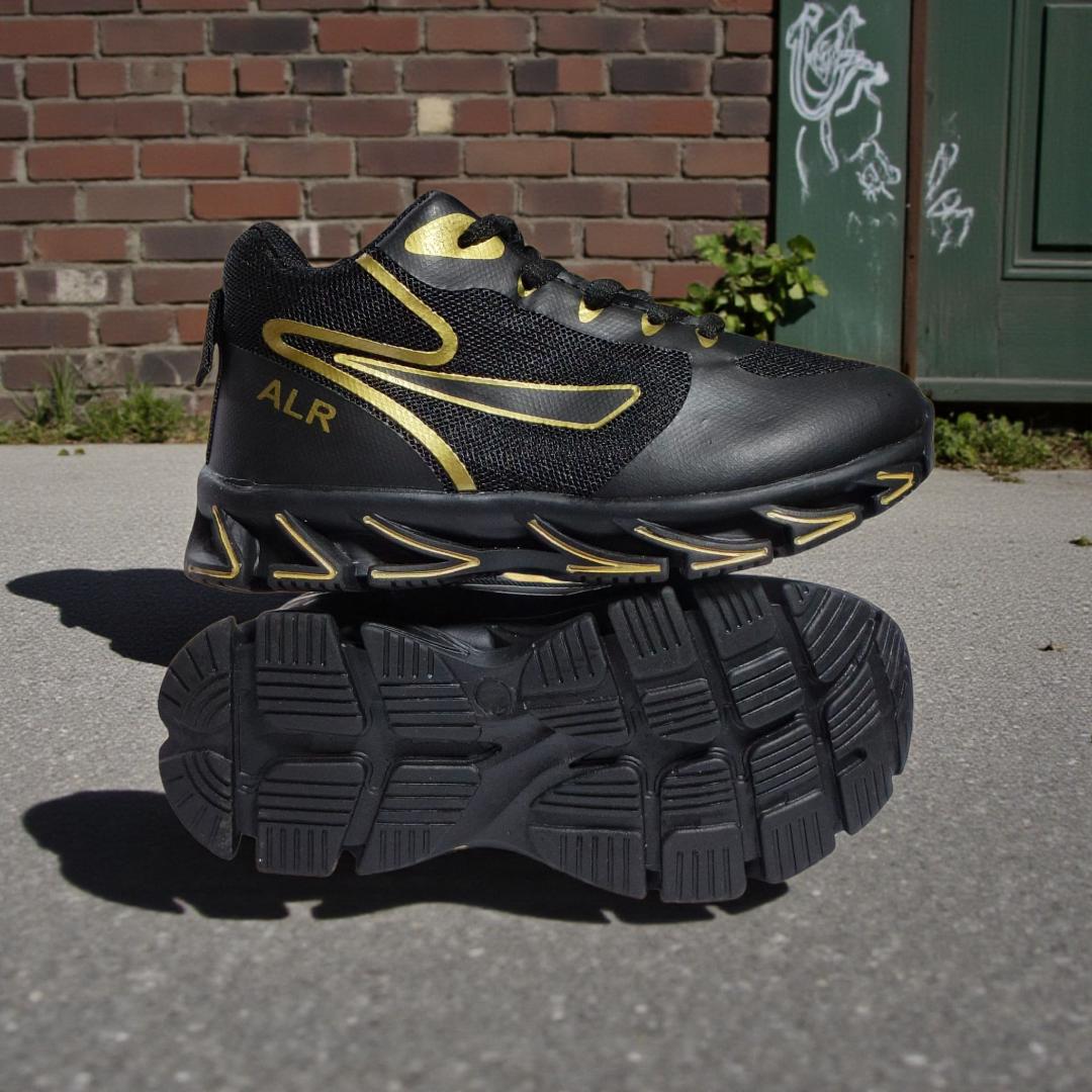 ALR V-Design Athletic kids Shoes. The shoes feature a black color scheme with white, gold,red and orange accents. Suitable for sports and averyday wear.