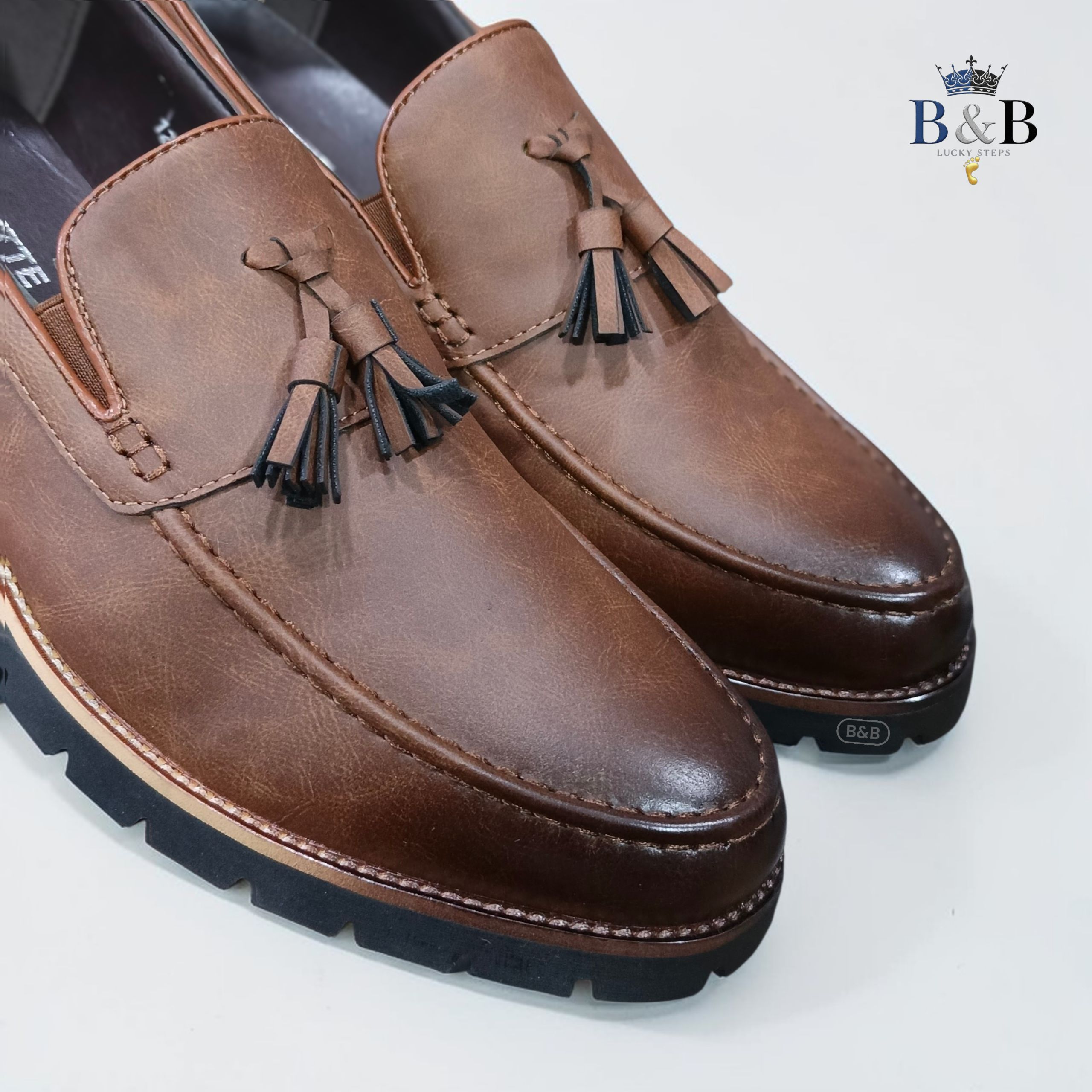 The Hybrid Loafer. Men's Rugged Tassel Loafers in Burnished Walnut,  Heritage Leather Slip-Ons with Commando Lug Soles. Men’s Toffee Brown Faux-Leather Loafers with Cleated Treads.