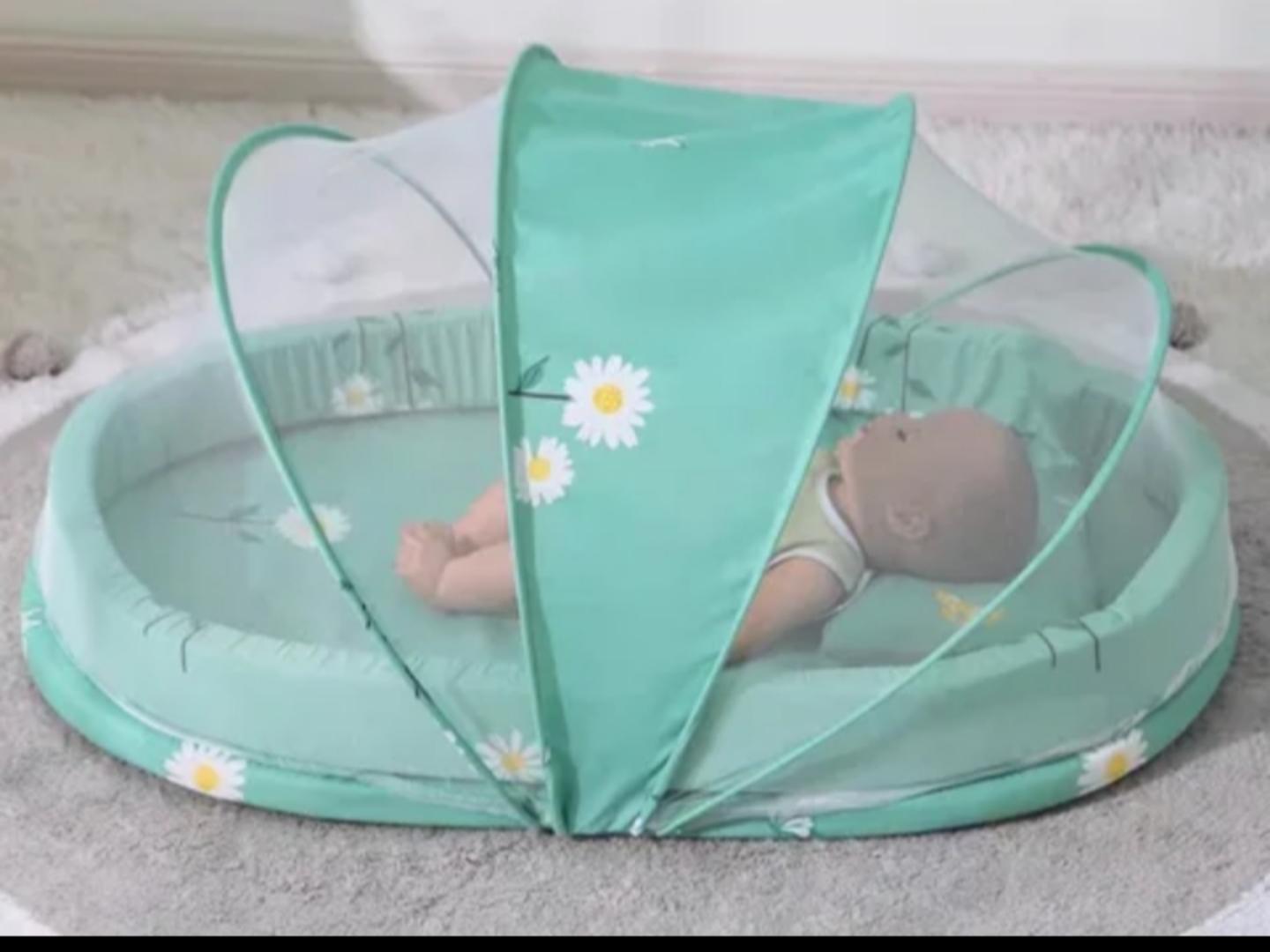 Portable baby bed with an integrated mosquito net head pillow designed for infant sleep and protection