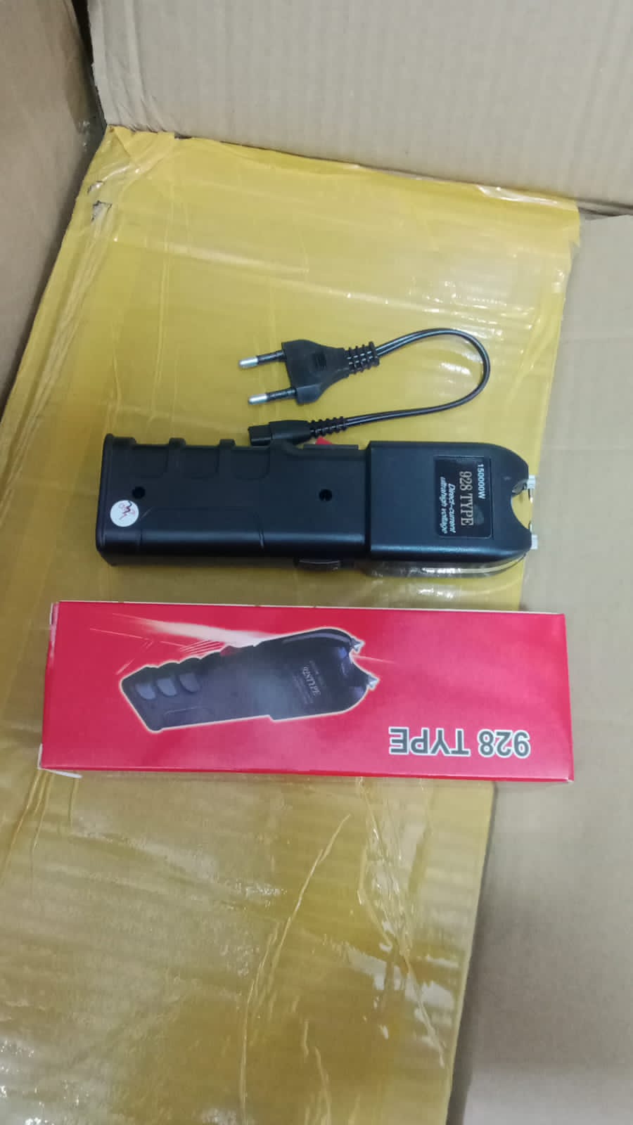 stun gun (electroshock weapon), specifically labeled as “928 TYPE” with “15000kV” marking on it. These devices are used for self-defense, delivering an electric shock intended to temporarily