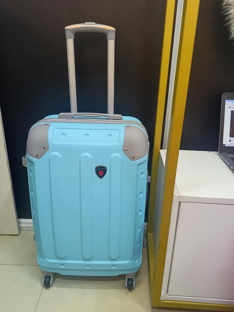 small fibre light blue suitcase with grey corners.