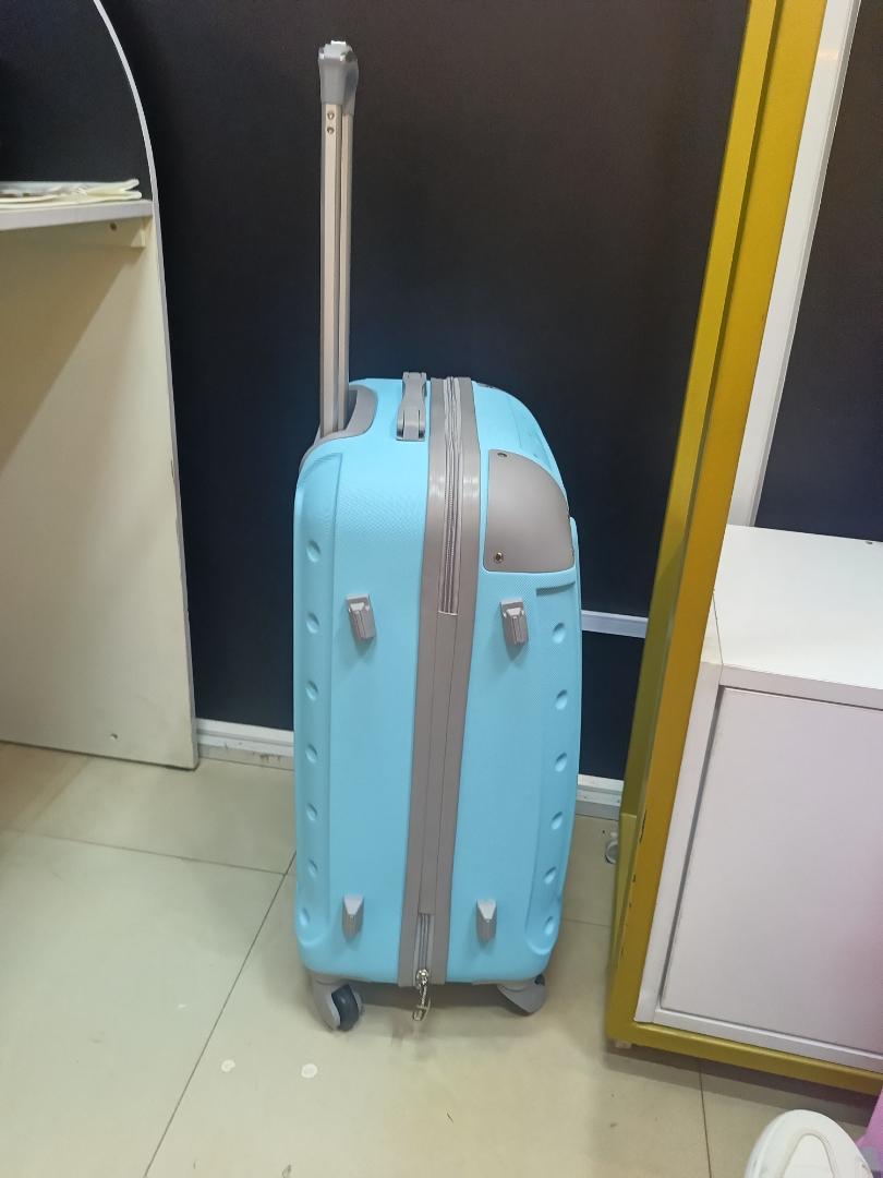small fibre light blue suitcase with grey corners.