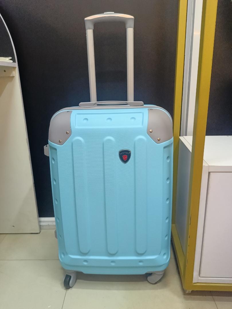small fibre light blue suitcase with grey corners.