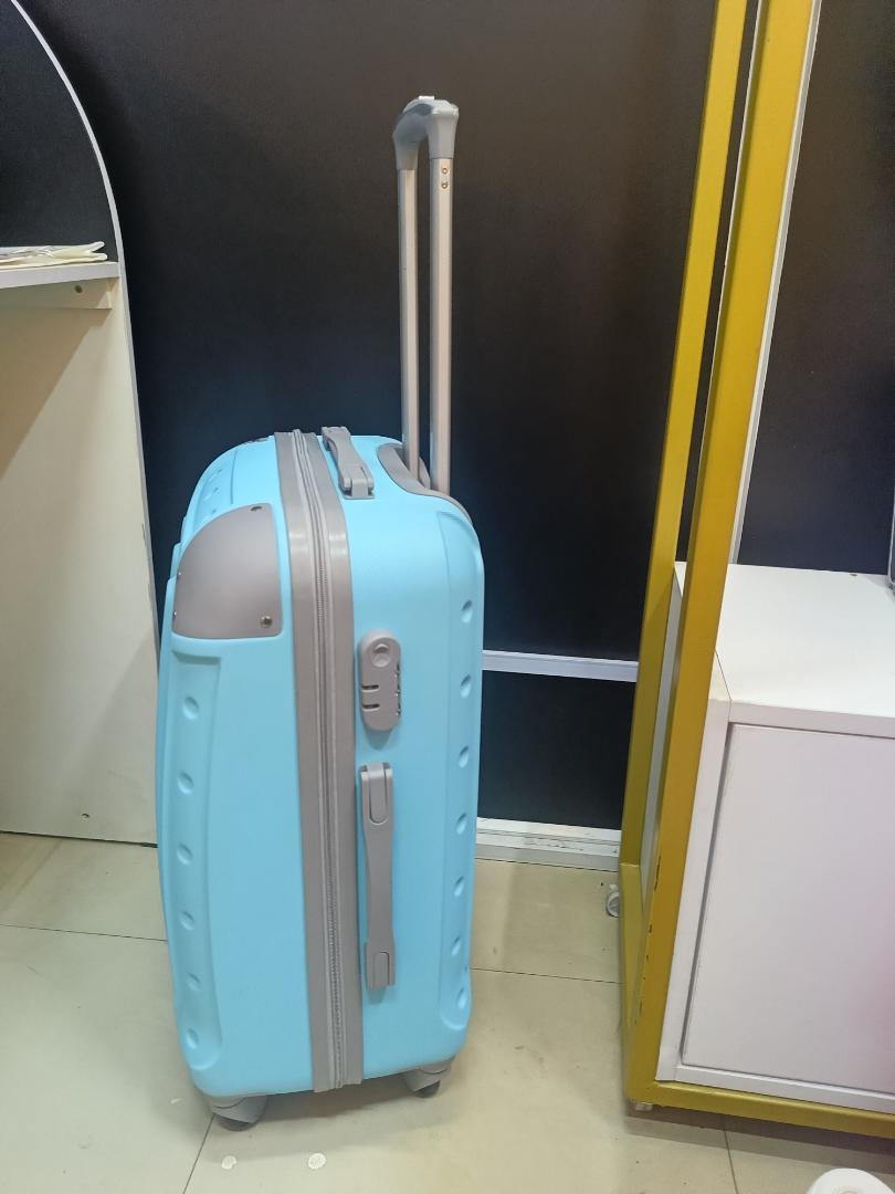 small fibre light blue suitcase with grey corners.