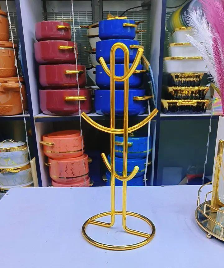 Heavy golden cup holder 

Now availableThis mug tree stores and displays up to six of your favorite coffee mugs and teacups in a fashionable manner. Made from stainless steel, the round mug stand has