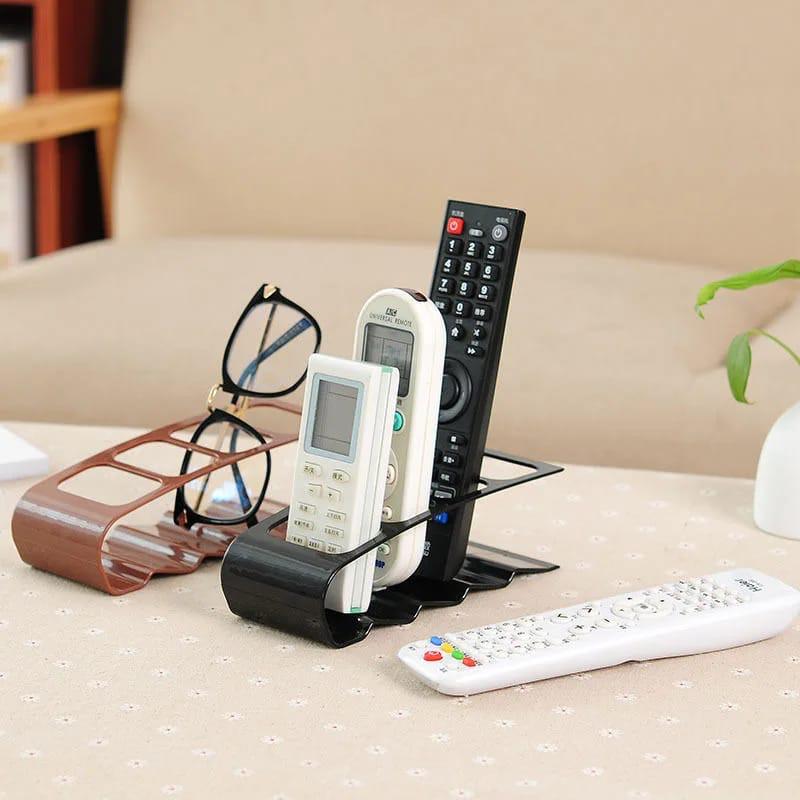 Remote Organizer . Remote control organizer rack featuring a convenient curved shape and a black finish. The curved, fan-like design keeps all 4 slots arranged so that the remotes you store inside.