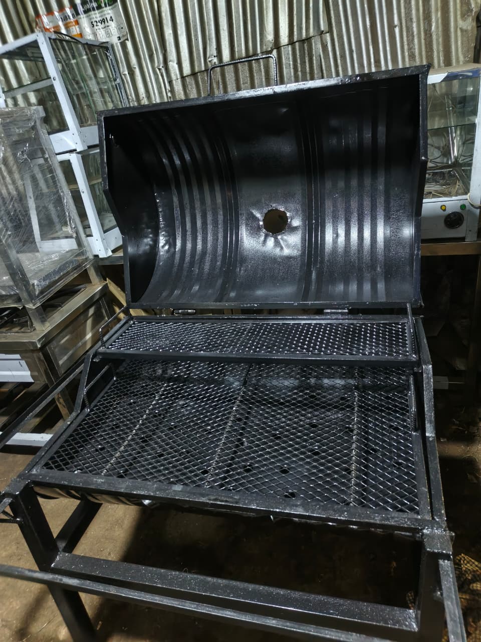 charcoal grill, often referred to as a barbecue pit or smoker, specifically known as a Churrasqueira a bafo.
Key features and details:
Construction: It appears to be constructed from a repurposed meta