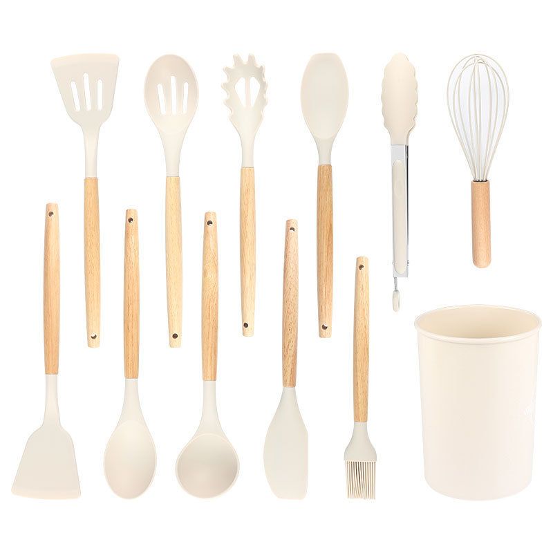 This is a set of silicone kitchen utensils, including spatulas and spoons, stored in a branded container. Heat - resistant and non - stick, they protect cookware from scratches.。