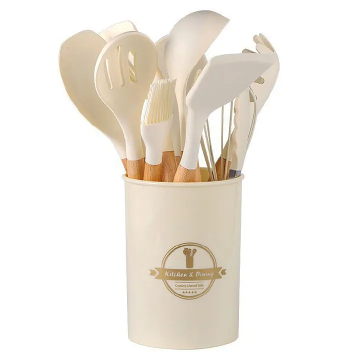 This is a set of silicone kitchen utensils, including spatulas and spoons, stored in a branded container. Heat - resistant and non - stick, they protect cookware from scratches.。