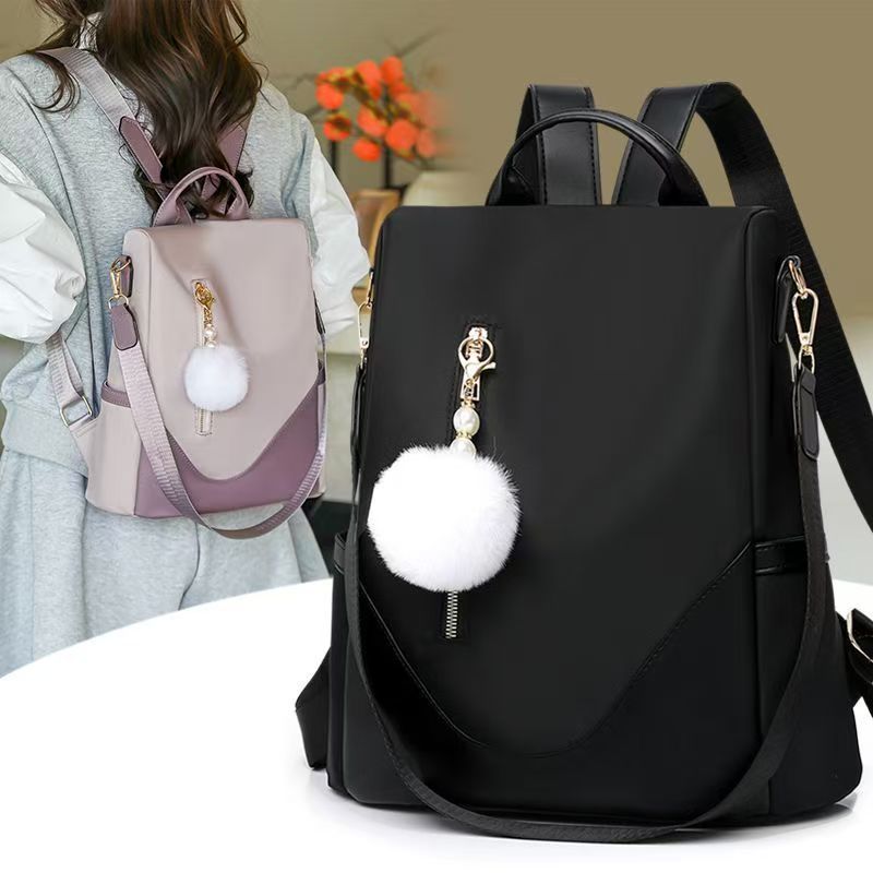 Trendy women’s backpack: white pom-pom charm, adjustable straps. Spacious, stylish & versatile—perfect for Kenyan young ladies’ daily outings/work.