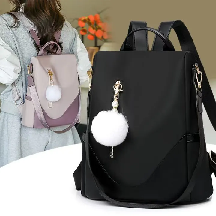 Trendy women’s backpack: white pom-pom charm, adjustable straps. Spacious, stylish & versatile—perfect for Kenyan young ladies’ daily outings/work.