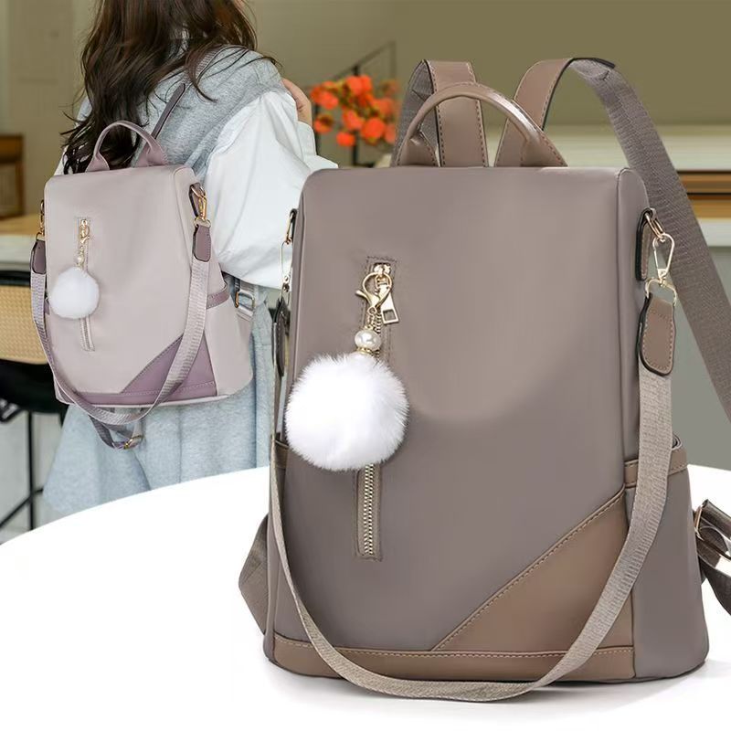 Trendy women’s backpack: white pom-pom charm, adjustable straps. Spacious, stylish & versatile—perfect for Kenyan young ladies’ daily outings/work.