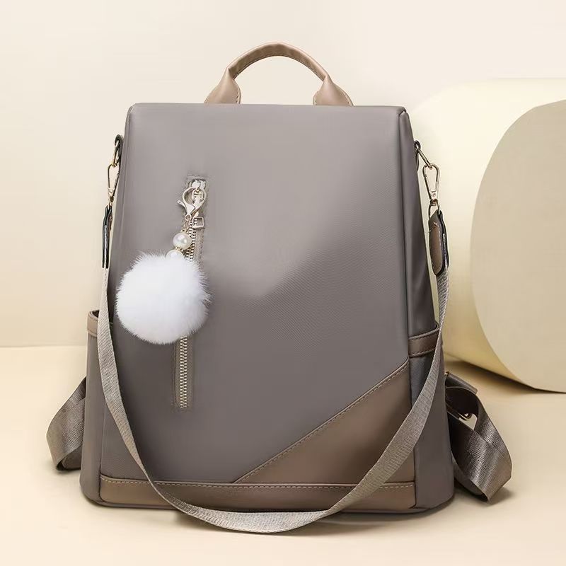 Trendy women’s backpack: white pom-pom charm, adjustable straps. Spacious, stylish & versatile—perfect for Kenyan young ladies’ daily outings/work.