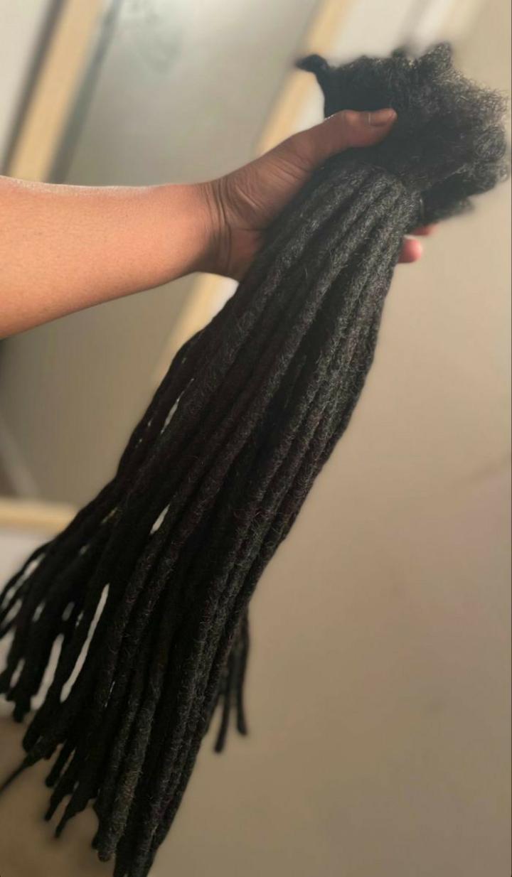 Artificial dreadlock extensions are pre-made dreadlock-like strands, typically made of synthetic hair, that are attached to natural hair to create the appearance of dreadlocks without the long-term co