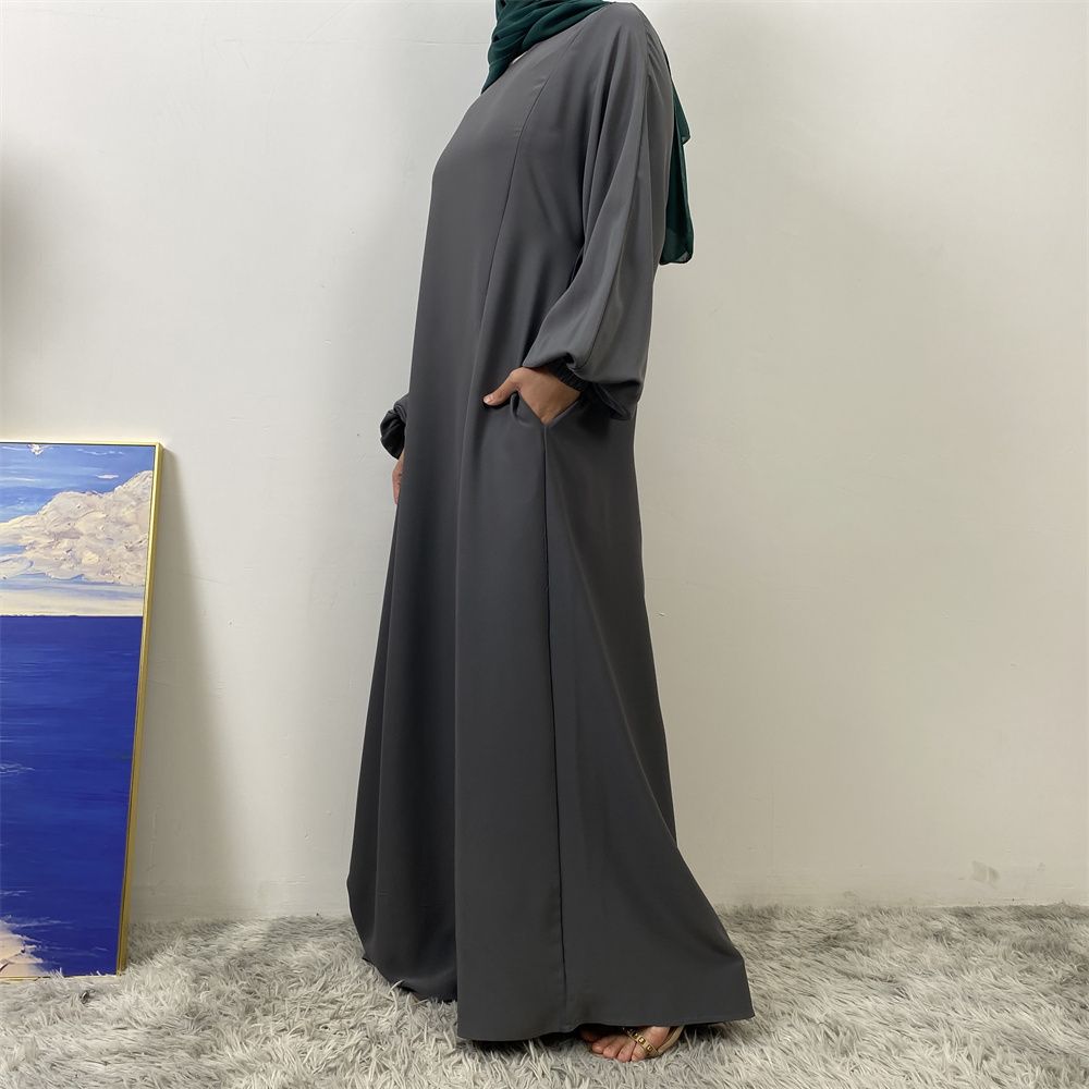 A slit, solid-color, one-shoulder sleeved Muslim dress is selling well in Dubai, Middle East