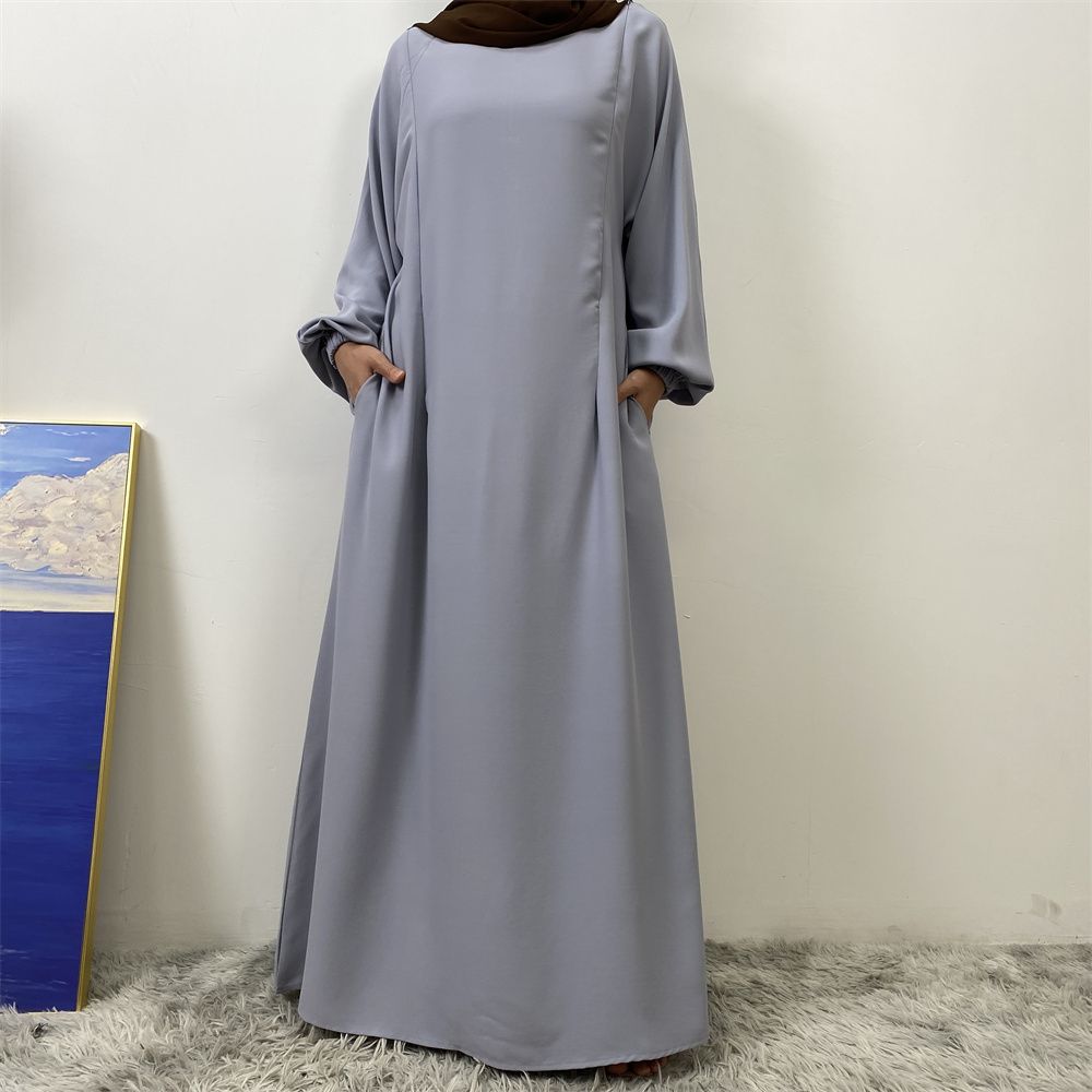 A slit, solid-color, one-shoulder sleeved Muslim dress is selling well in Dubai, Middle East