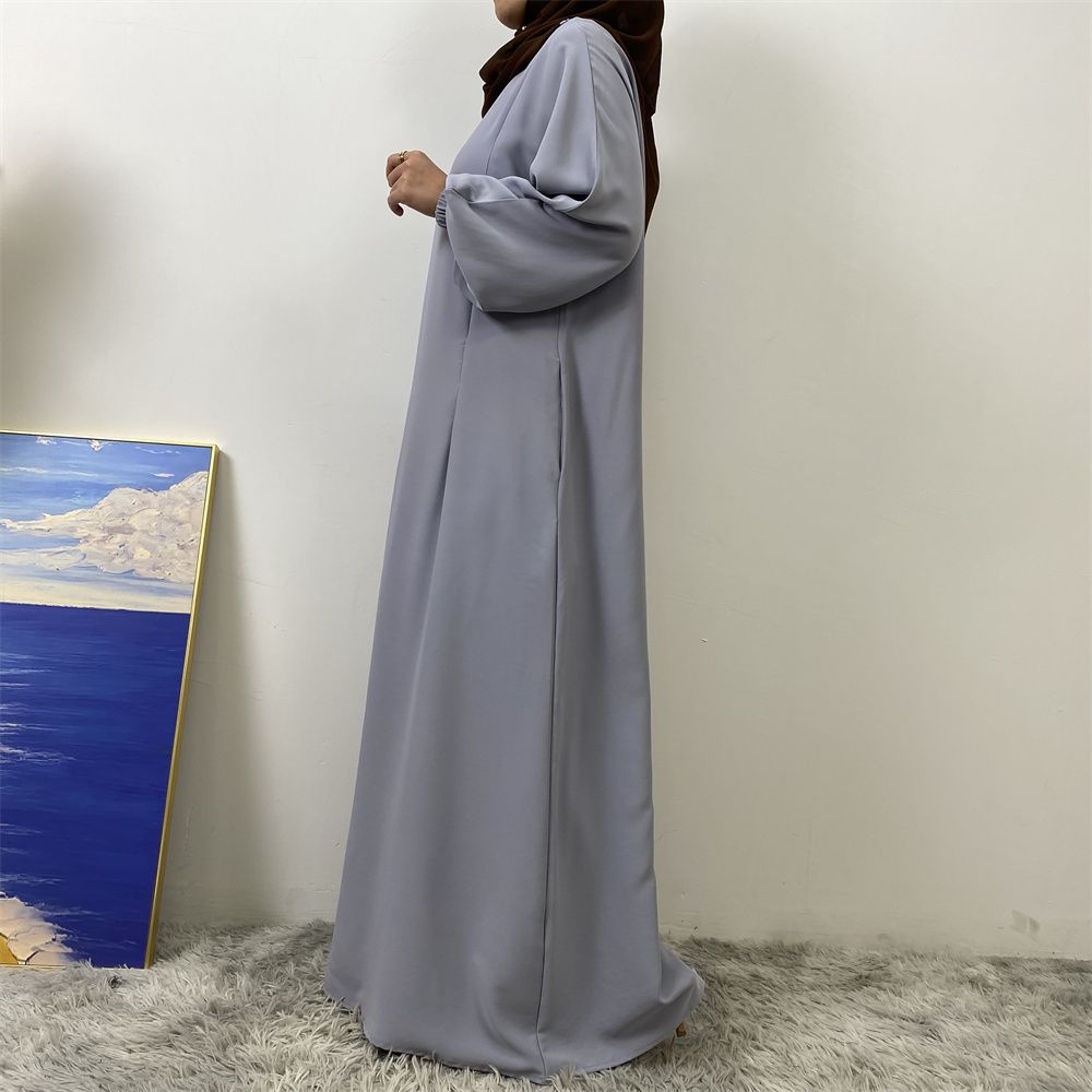 A slit, solid-color, one-shoulder sleeved Muslim dress is selling well in Dubai, Middle East