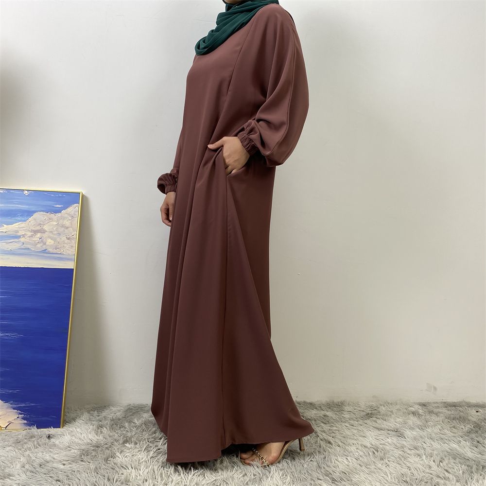 A slit, solid-color, one-shoulder sleeved Muslim dress is selling well in Dubai, Middle East