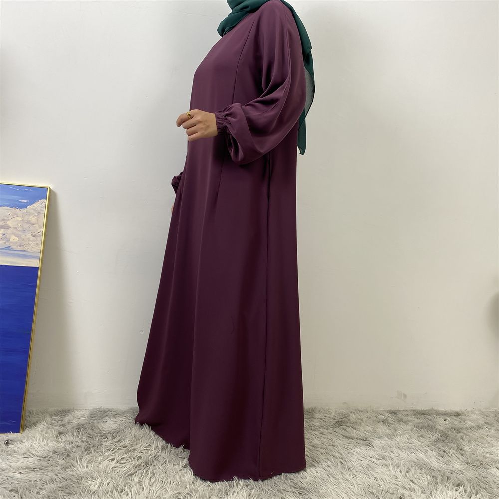 A slit, solid-color, one-shoulder sleeved Muslim dress is selling well in Dubai, Middle East