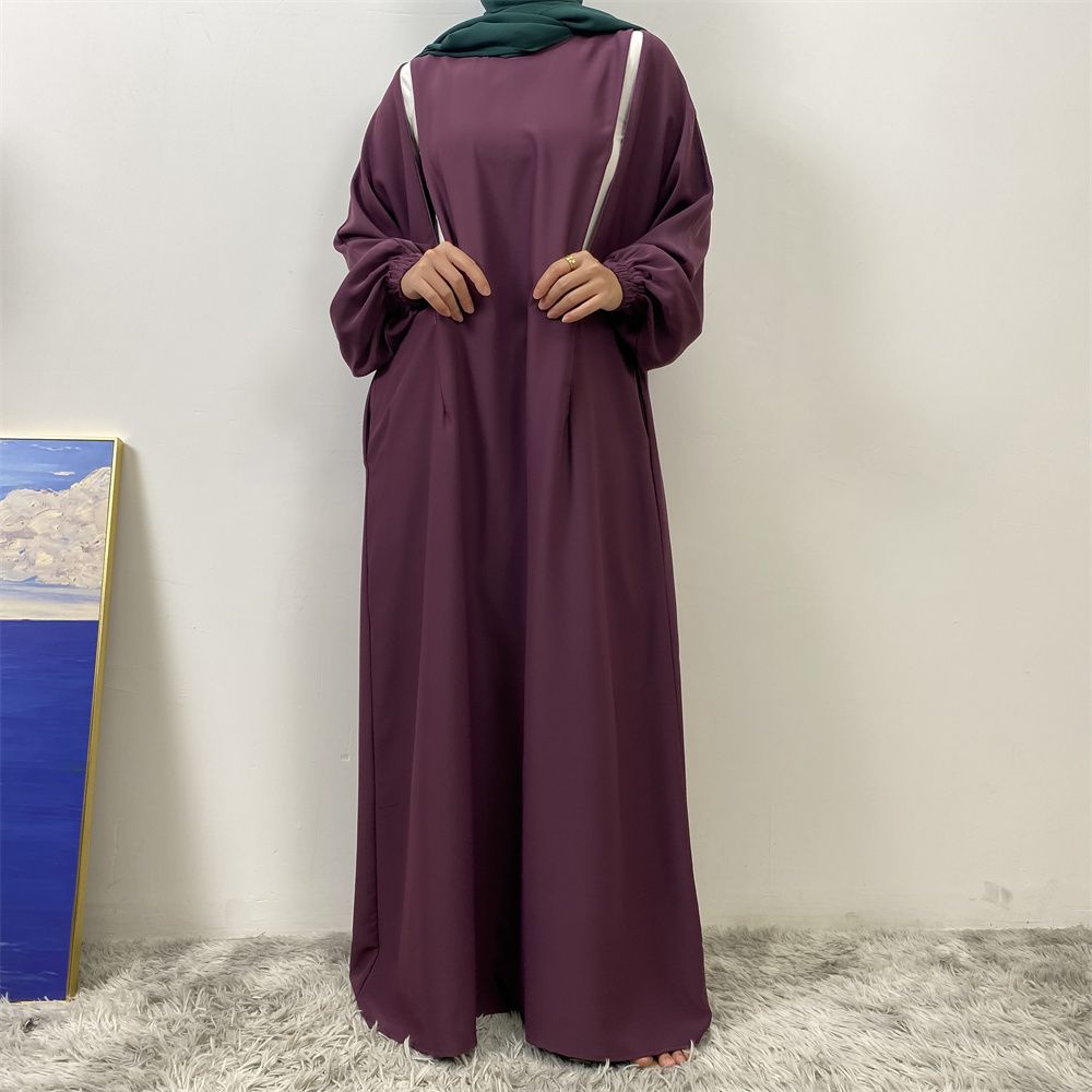 A slit, solid-color, one-shoulder sleeved Muslim dress is selling well in Dubai, Middle East