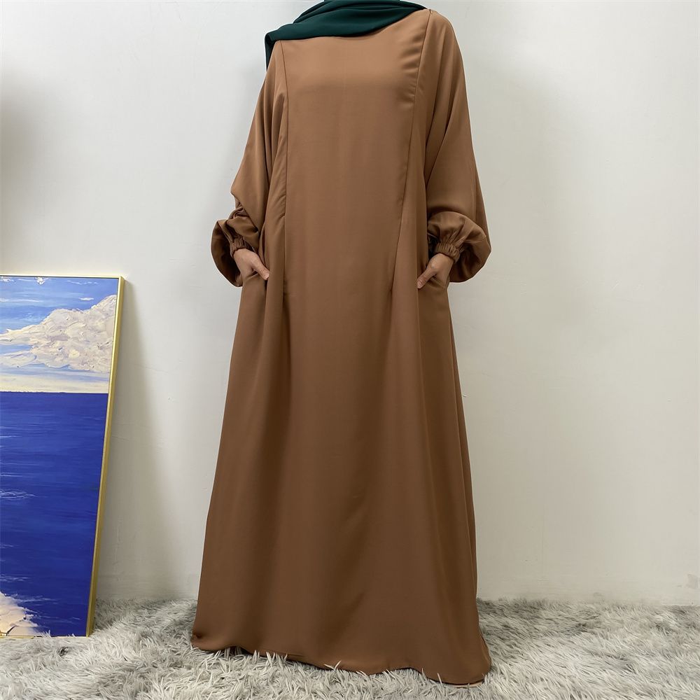 A slit, solid-color, one-shoulder sleeved Muslim dress is selling well in Dubai, Middle East