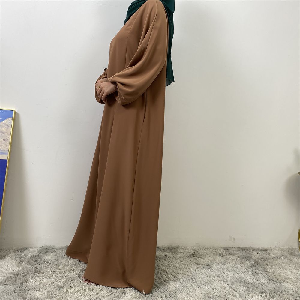 A slit, solid-color, one-shoulder sleeved Muslim dress is selling well in Dubai, Middle East