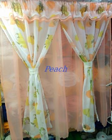 kitchen curtain. It appears to be a sheer curtain with a pineapple pattern. The curtain is tied back to let in light.