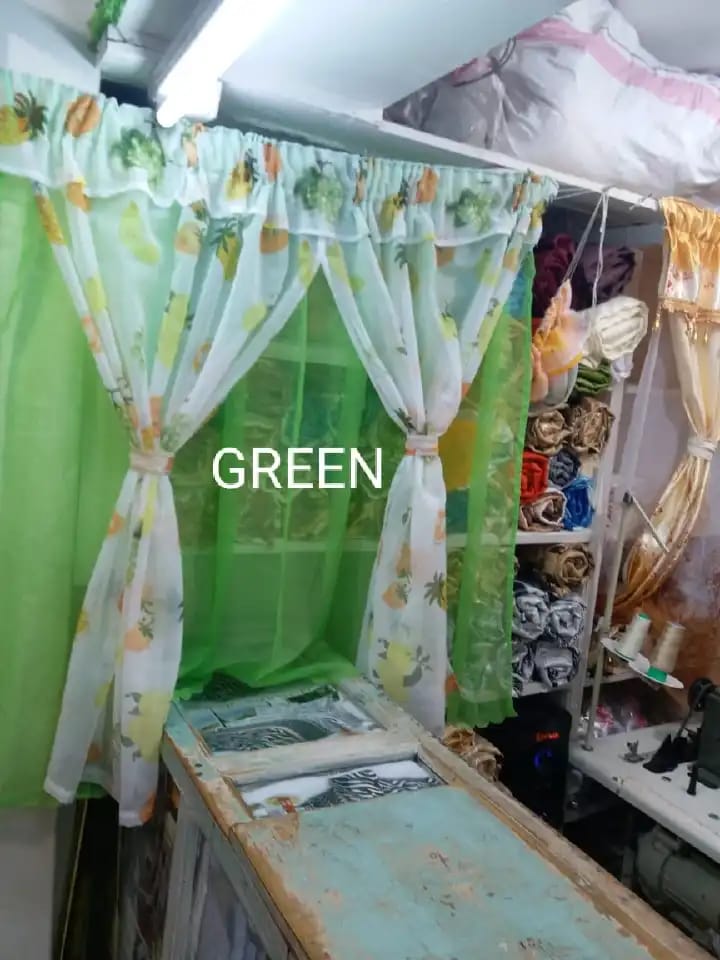 kitchen curtain. It appears to be a sheer curtain with a pineapple pattern. The curtain is tied back to let in light.