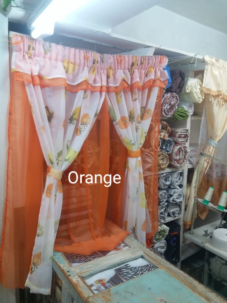 kitchen curtain. It appears to be a sheer curtain with a pineapple pattern. The curtain is tied back to let in light.