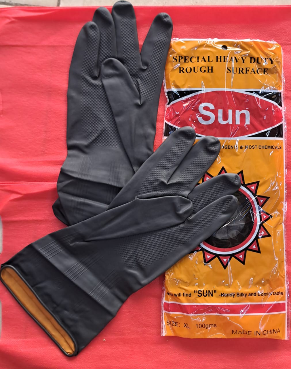 pair of Sun Heavy Duty Rough Surface rubber gloves. 
Made from natural latex rubber.
Provides high resistance to water-based chemicals, acids, and detergents.
Features a textured grip for be