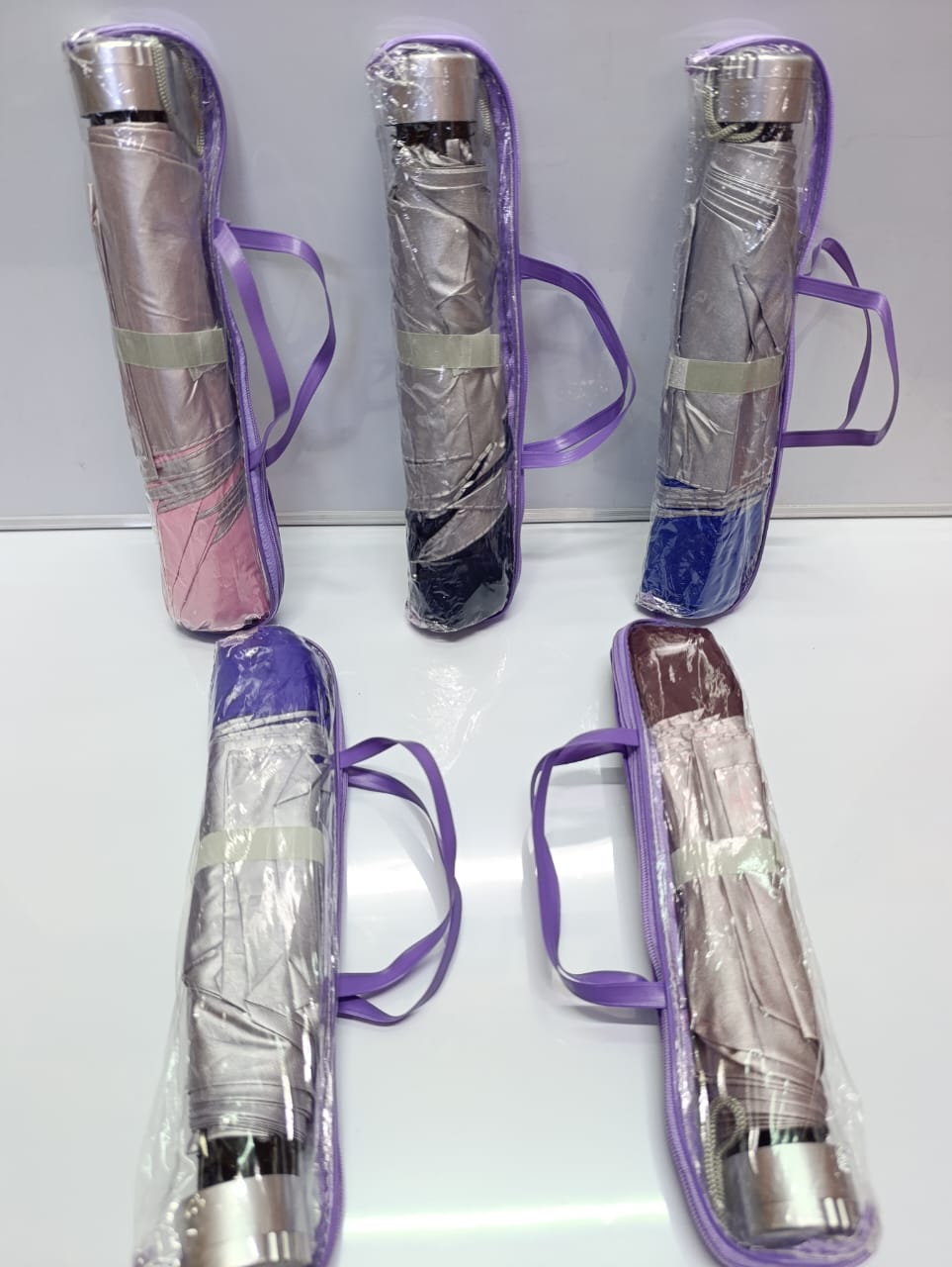 compact, manual folding umbrellas in various colors. 
These umbrellas are designed to be small and portable, often fitting into a bag or pocket when folded. 
They typically feature a strong, water-rep