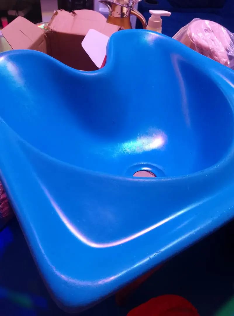 portable salon sink basin, typically used for hair washing in salons, barber shops, or homes. 

This type of sink is often made of durable materials like fiberglass or ABS composite. 

The design is o