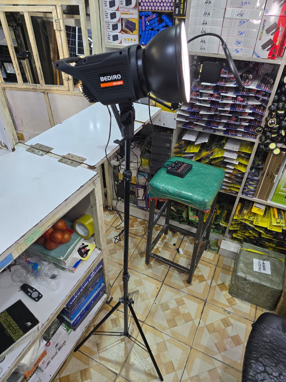 Bediro BD-400S studio light mounted on a light stand in a store. This type of continuous lighting equipment is used for photography, filming, and live streaming. 
The lamp has a power capacity of 100W