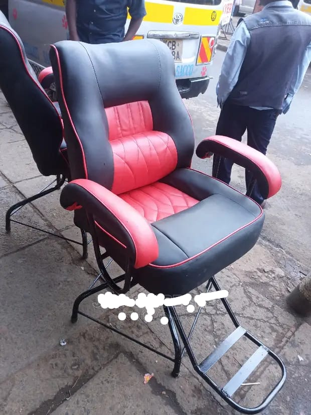 barber chair. These chairs are a common piece of furniture for barbershops and salons, designed for both style and function. 
Design: The chair in the image is black and red with a cushioned seat, bac