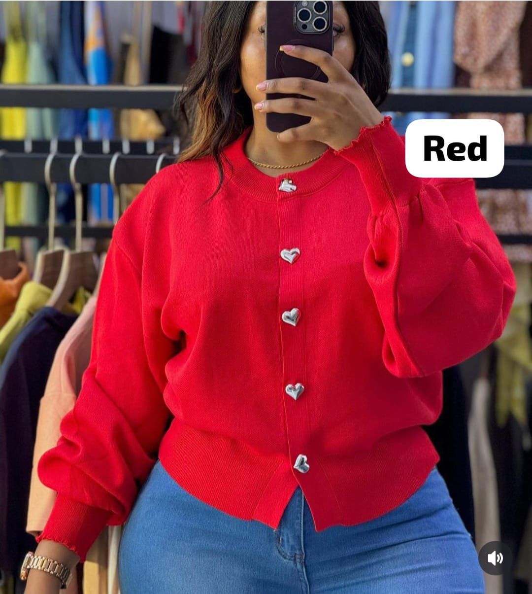 A knitted cardigan or sweater top characterized by its prominent silver/gold-tone heart-shaped buttons and has a slightly cropped length with long, voluminous balloon sleeves that end in ribbed cuffs.