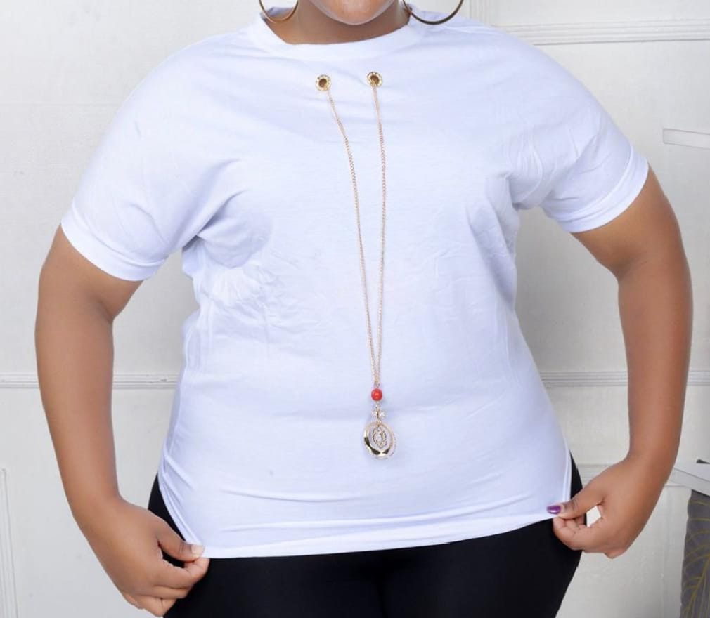 Women Essential Luxe Classic Tee with a long gold-tone necklace with a red bead and circular pendant. Size: Free size