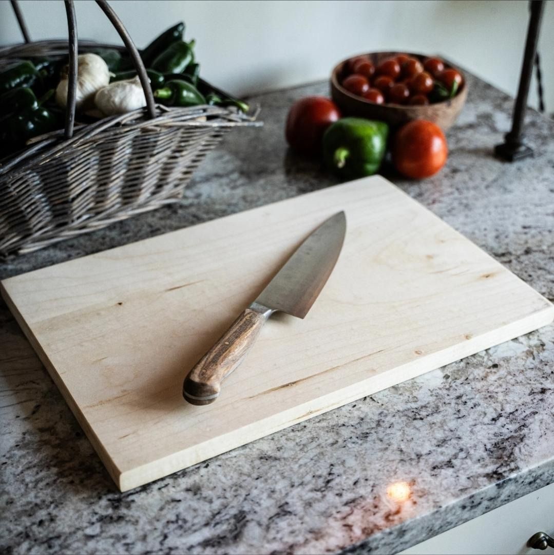 A wood cutting board and a stainless steel knife