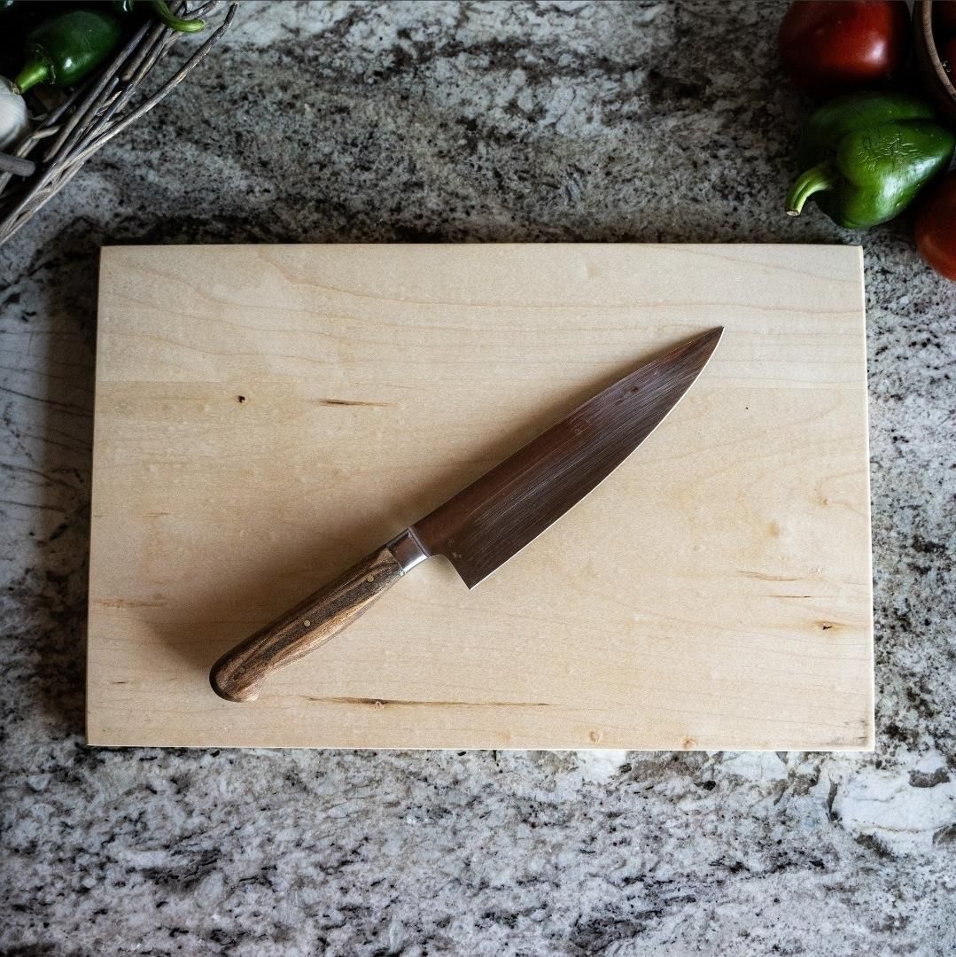 A wood cutting board and a stainless steel knife