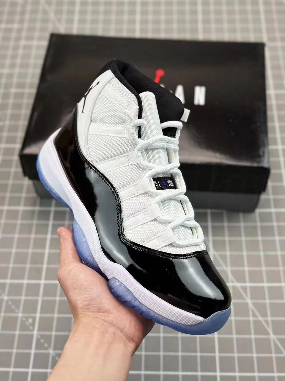 Iconic Air Jordan 11 sneakers featuring glossy patent leather, breathable mesh upper, responsive cushioning, and durable rubber outsole. Timeless design delivering premium comfort, style,