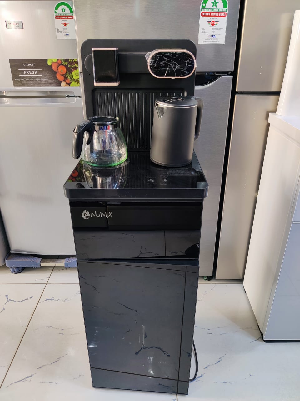 Black and silver Nunix A1C Bottom Load Hot And Cold Water Dispenser - Smarter and Stronger,Automatic Kettle Filling,Two free electric Kettles, Water Container cabinet at the bottom,Overheat Protection