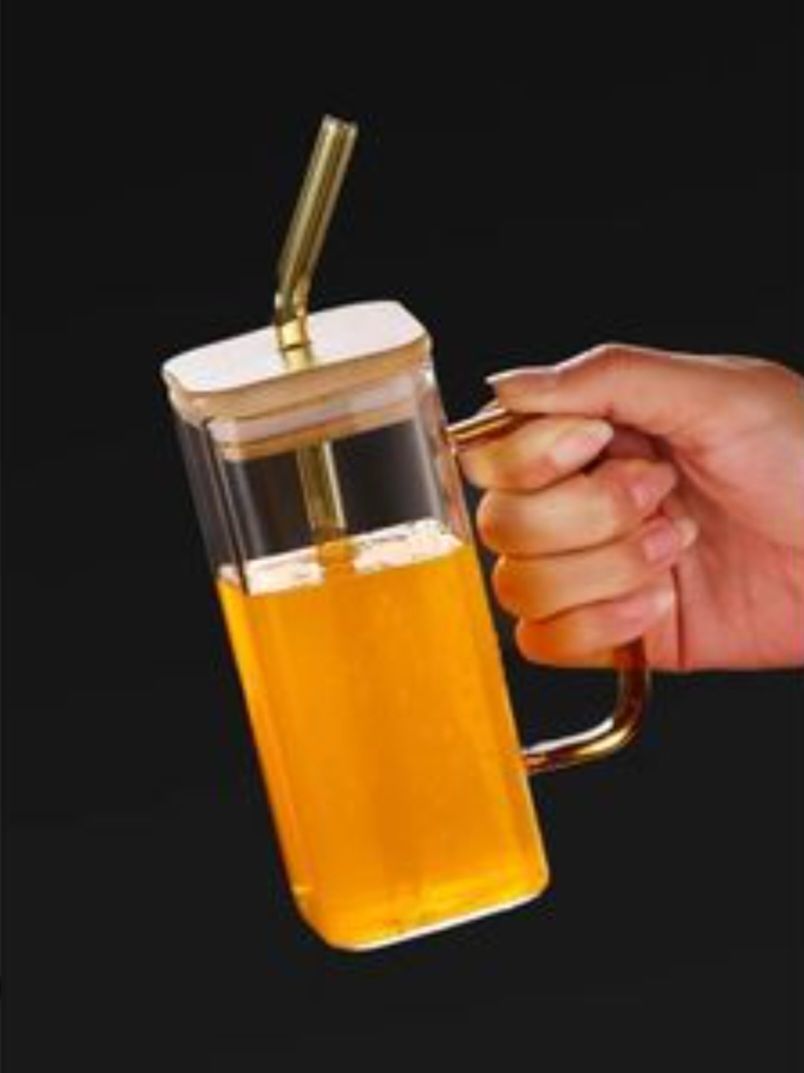 Glass mug features a bamboo lid and a straw, ideal for both hot and cold drinks.