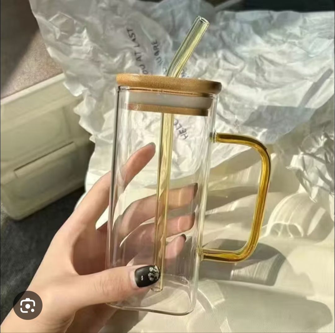 Glass mug features a bamboo lid and a straw, ideal for both hot and cold drinks.