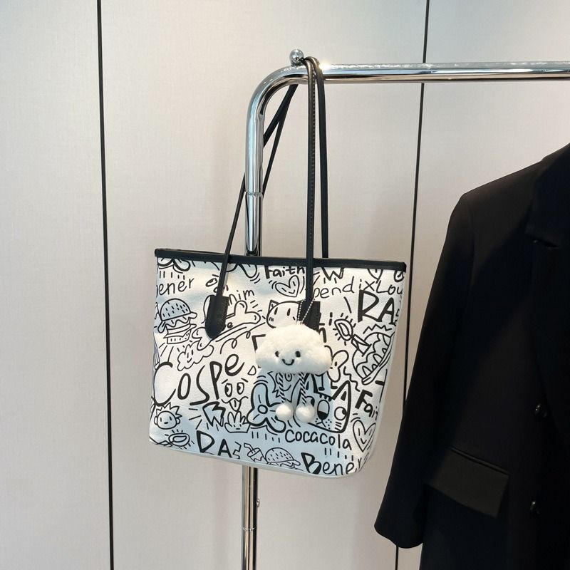 🔥 TRENDY GRAFFITI TOTE!!! Women’s Canvas Shoulder Bag – Large Capacity Tote with Cute Teddy Pendant.Made from durable canvas material, it’s lightweight yet strong enough to carry all
