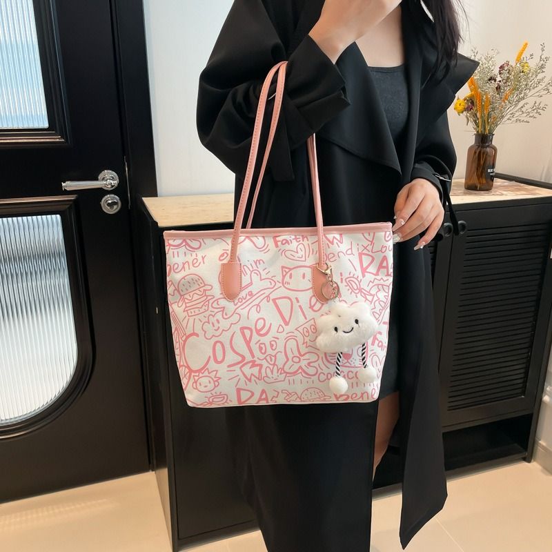 🔥 TRENDY GRAFFITI TOTE!!! Women’s Canvas Shoulder Bag – Large Capacity Tote with Cute Teddy Pendant.Made from durable canvas material, it’s lightweight yet strong enough to carry all
