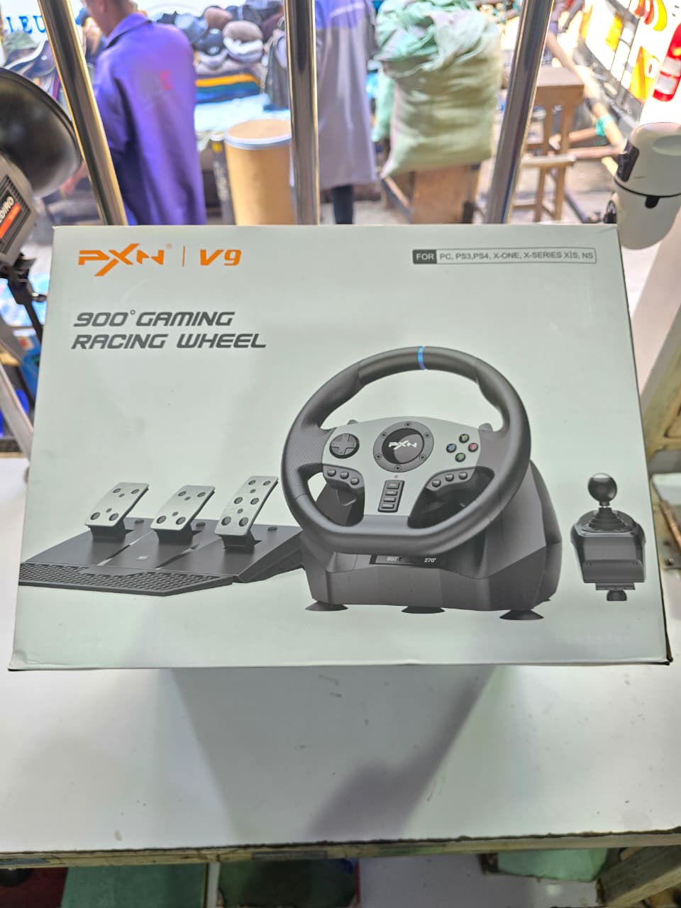 PXN V9 900° Gaming Racing Wheel. This is a gaming accessory designed for racing simulation games, featuring a steering wheel, pedals (for acceleration, braking, and clutch), and a shifter. It offers a