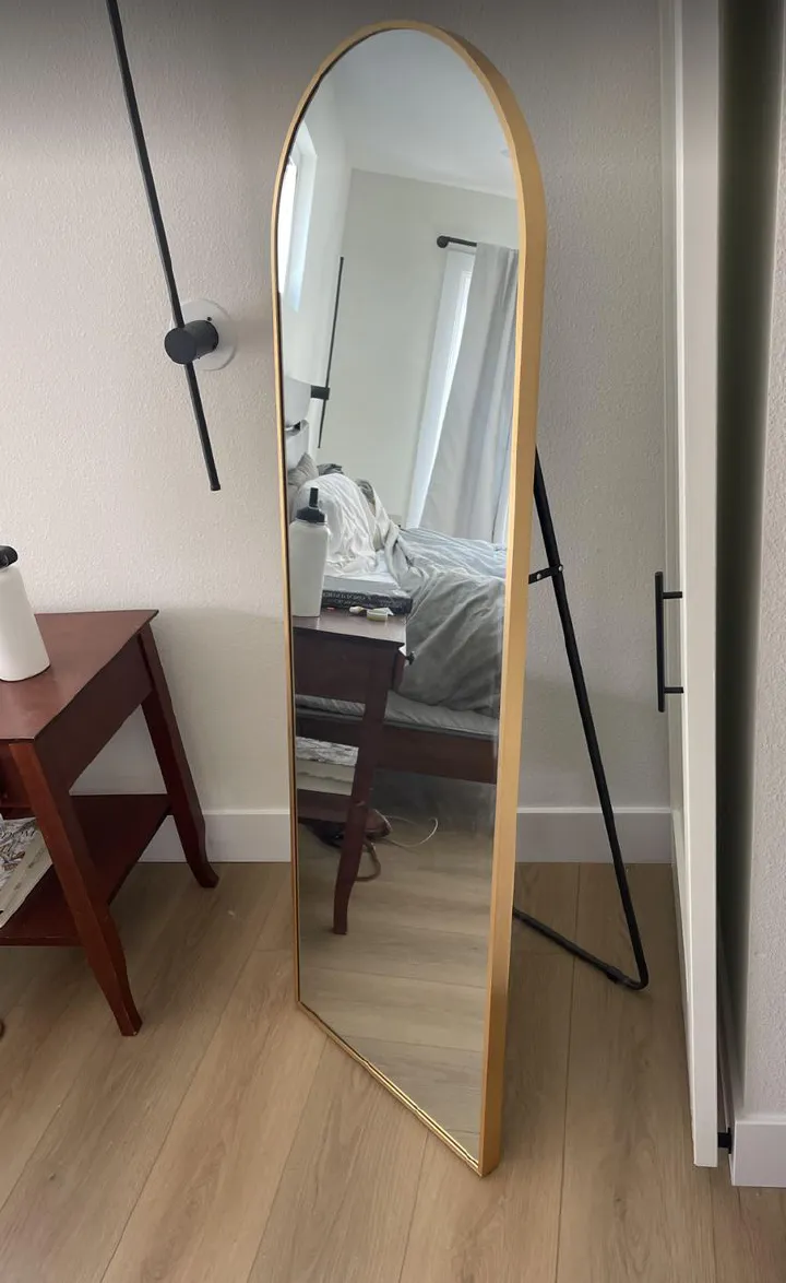 ✅️AVAILABLE AT THE SHOP✅️Free Standing Dressing Mirror With Wheels.Elevate your home decor and personal style with this elegant full-length standing mirror. Featuring a sleek, arched design and a stur