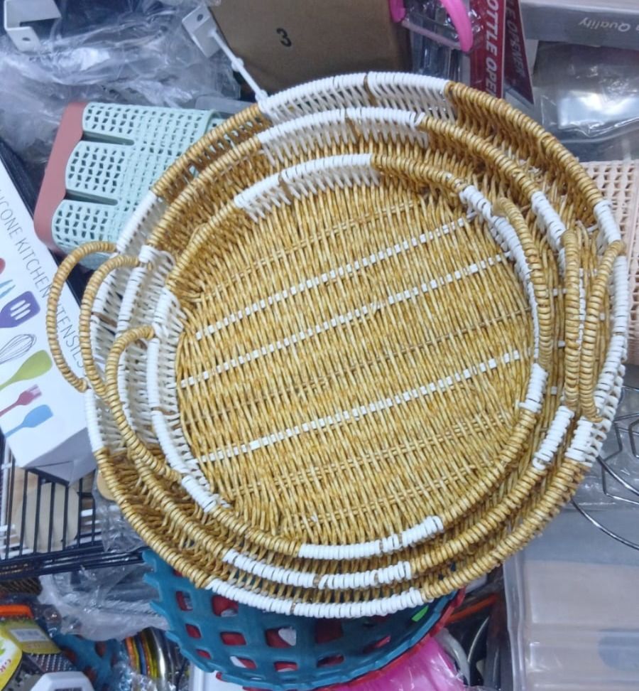 WOVEN TRAYS. A Set of Three Round Woven Serving Trays With Handles, Used for serving food, drinks, or as decorative organizing baskets on a coffee table, ottoman, or kitchen counter.